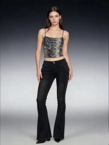 Detail shot of vintage low-rise black slim flared jeans styled with a graphic crop top