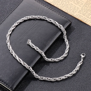 Detailed shot of a silver twist texture chain necklace with lobster clasp on leather