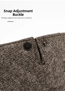 Macro detail of adjustable metal buckle on herringbone tweed newsboy cap fabric