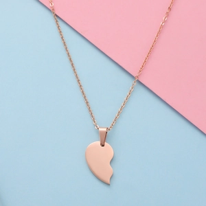Polished rose gold half-heart pendant necklace displayed on a soft pastel background