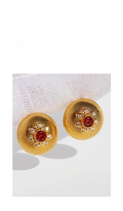 Detail of vintage round gold stud earrings with red zircon and sparkling white crystals