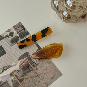 Detail view of retro amber tortoiseshell hair clips with elegant marble patterns set