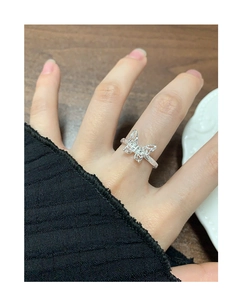 Detailed close-up of a sterling silver hollow butterfly ring worn on a finger