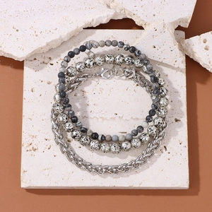 Close-up of grey marble beads and silver chain bracelet set for men on stone