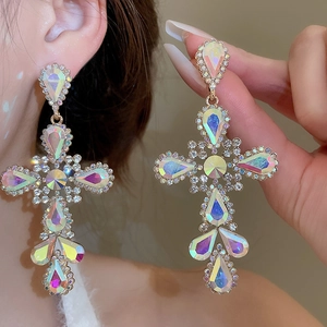 Macro detail of colorful crystal cross earrings with shimmering AB rhinestones and gold plating
