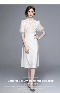 Détail des manches bouffantes blanches avec perles et dentelle sur la robe élégante