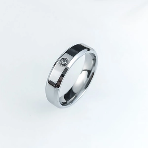 Macro view of polished stainless steel ring band with central sparkling crystal stone