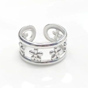 Macro view of silver titanium steel open ring featuring delicate double-layer flower patterns