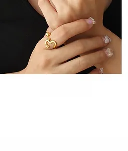 Detail eines minimalistischen wellenförmigen Goldrings mit Kugel am Ende an der Modellhand