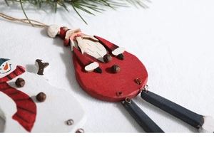 Detail of wooden painted Christmas ornaments with bells and snowmen for tree decoration