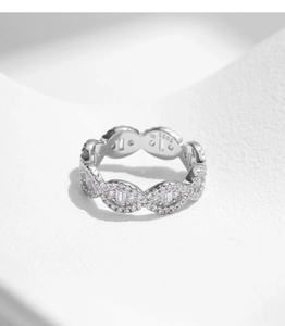 Macro shot of S925 silver wave chain ring featuring luxury baguette and round cut stones