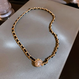 Détail de la chaîne en simili cuir avec une boule sertie de strass brillants