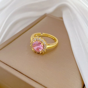 Vue détaillée d'une bague en cristal rose avec halo de diamants sur satin de soie