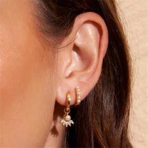 Close-up of gold s925 silver hoop earrings with marquise diamonds and elegant pearls