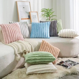 Close-up of assorted faux rabbit fur pillow covers with plush striped texture and soft colors