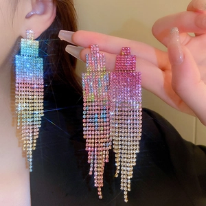 Gros plan de boucles d'oreilles à longs gland avec des strass dégradés rose et violet