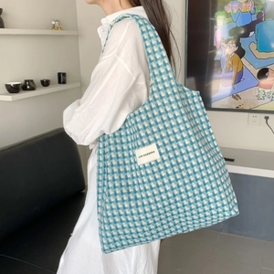 Detail of blue and white checkered woven tote bag with LOVE SOZAKKA label on strap