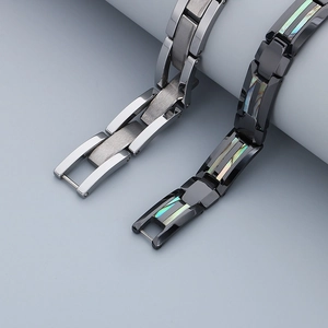 Gros plan de bracelets en acier brossé et tungstène noir avec incrustation d'abalone