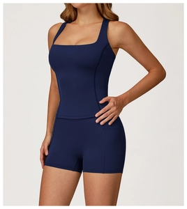 Dettaglio del top da yoga blu navy con spalline larghe e scollo squadrato sulla modella