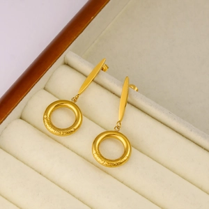 Macro view of gold hoop earrings with vintage engraving on jewelry box tray