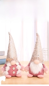 Detailed view of pink sequin gnome dolls on a wooden table with festive plush textures