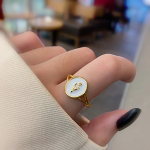 Macro shot of 18k gold plated ring featuring white round shell with a tulip relief detail