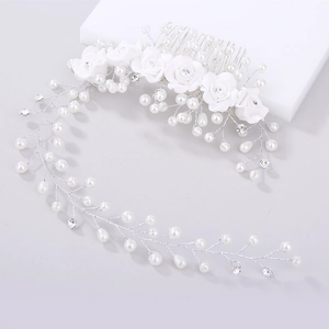 Detail of bridal hair comb with white ceramic roses, pearls and sparkling rhinestones