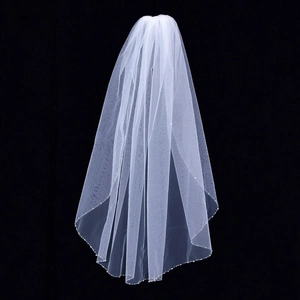 Detailed close-up of white bridal veil featuring delicate hand-beaded tassels and pearls