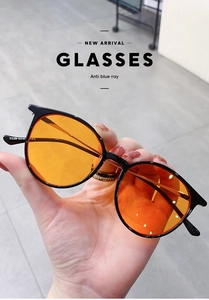 Detail shot of black round frames with orange lenses and temple specification 9328
