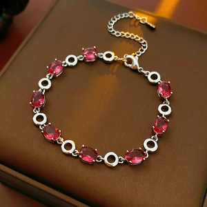 Detail of red oval gemstone bracelet with silver metal chain on jewelry box