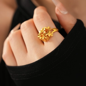 Close-up of a 24k gold-plated flower cluster ring on a model's finger with zircon details
