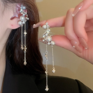 Detail of elegant pearl drop earring with long tassel chain and sparkling rhinestones