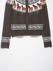 Detail of multi-color jacquard knit cardigan with animal pattern and brown buttons