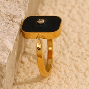 Macro view of 18K gold plated ring with black enamel square and crystal stone inlay