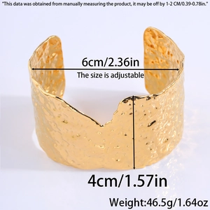 Detailed view of wide gold cuff bracelet featuring hammered texture and dimensions