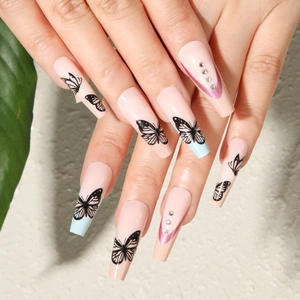 Press-on nails with butterfly motifs and sparkling rhinestones on long ballerina shape