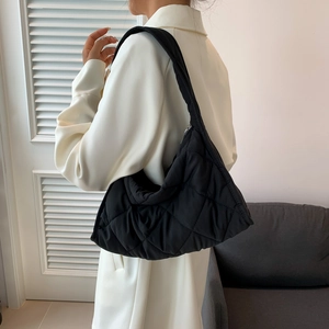 Close-up of black quilted nylon puffer shoulder bag showing texture and stitching