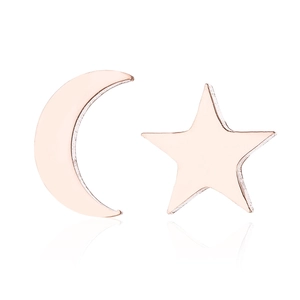 Close-up of rose gold asymmetrical star and moon earrings on a white mirror background