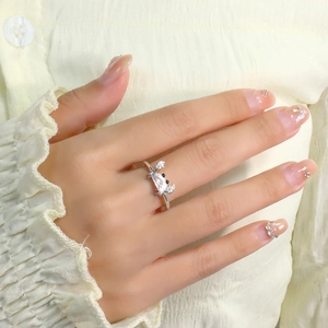 Detail of silver crab ring with clear zircons on model's hand and yellow shirt