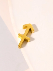 Macro detail of golden Sagittarius zodiac pendant with polished finish on beige background