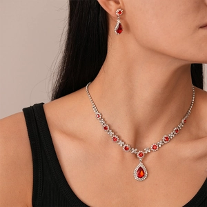 Detail of model wearing red teardrop crystal jewelry set with silver necklace and earrings