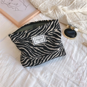 Detailed close-up of zebra print chenille makeup bag with TIME TO PARTY patch