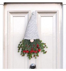 Détail d'une couronne de gnome de Noël avec aiguilles de pin et petites baies rouges