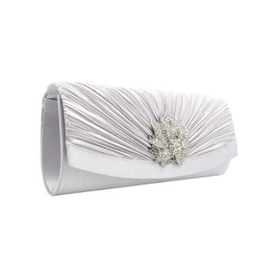 Detailed side view of silver satin pleated evening clutch with leaf rhinestone buckle