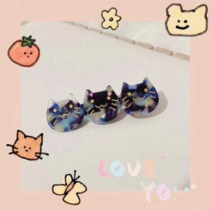 Detail view of acetate hair clip featuring three blue-purple marble pattern cats with gold whiskers