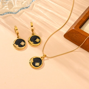 Détails d'ensemble bijoux dorés avec émail noir et pendentif soleil en zircone