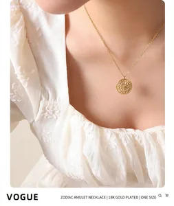 Close-up of golden coin necklace with sunburst engraving and zircons on a model