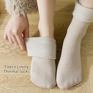 Thick beige winter snow socks with warm fleece lining shown on wooden floor