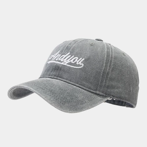 Close-up of distressed gray cotton baseball cap with white Andyou cursive embroidery