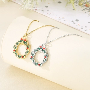 Detailed close-up of gold and silver Christmas wreath necklaces with red bow and rhinestones